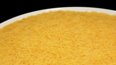 Raw Uncooked Noodles on White Plate Rotating against Black Background. Dry Vermicelli Turning Around. Raw Pasta
