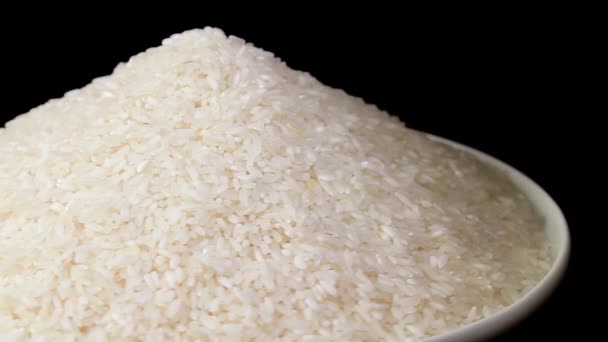 Dry Uncooked White Rice Heap White Plate Rotating Black Background — ストック動画