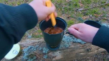 Camp Food. Cooking in a Hike Using a Small Cook Set - First Person View, Wide Angle. Food on the Trip. Traveler in a Spring Forest. Tourist in a Travel is Heating Food - POV Shot.