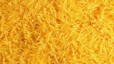 Saat Yönünde Yavaşça Dönen Pişmemiş Eriştelerin Arkaplanı - Üst Görünüm, Yakın Çekim. Kuru Vermicelli Dönüşü dokusu. Çiğ Makarna - Sağa Çevirme