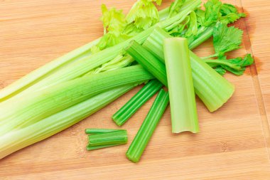 Taze Kereviz Kökü ve Tahta Kesme Tahtasında Doğranmış Kereviz Çubukları. Vejetaryen ve Vejetaryen Kültürü. Çiğ yemek. Sağlıklı beslenme ve negatif kalori içeriği. Zayıflatıcı Gıda