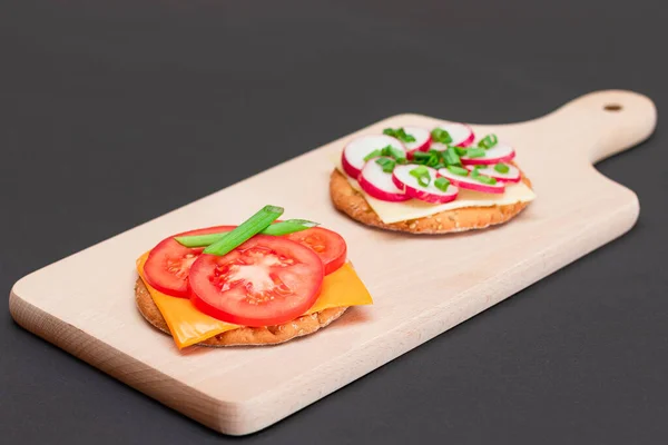 Different Cracker Sandwiches with Tomato, Cucumber, Radish and Cheese on Cutting Board. Easy Breakfast. Diet Food. Quick and Healthy Sandwiches. Crispbread with Tasty Filling. Healthy Dietary Snack