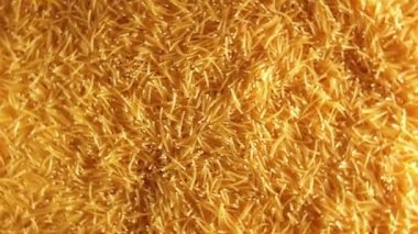 Saat Yönünde Dönen Pişmemiş Altın Eriştelerin Arkaplanı - Üst Görünüm. Kuru Vermicelli Dönüşü dokusu. Low Key Light ile Çiğ Makarna - Sağ Döndürme