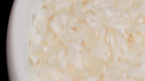 乾燥調理されていない白米回転 マクロ 散乱生長粒米 クローズアップ アジア料理と文化 健康的な食材 — ストック動画