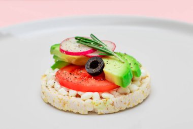 Avokado, domates, süzme peynir, zeytin ve turplu pirinç keki sandviçi. Kolay Kahvaltı 'da. Diyet yemek. Hızlı ve sağlıklı sandviçler. Lezzetli dolgulu kızarmış ekmek. Sağlıklı Beslenme Atıştırması