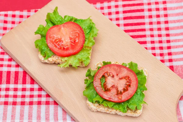 Rice Cake Sandwiches with Tomato and Lettuce on Wooden Cutting Board. Easy Breakfast. Diet Food. Quick and Healthy Sandwiches. Crispbread with Tasty Filling. Healthy Dietary Snack