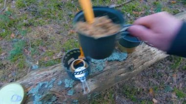 Camp Food. Cooking in a Hike Using a Small Cook Set - First Person View, Wide Angle. Food on the Trip. Traveler in a Spring Forest. Tourist in a Travel is Heating Food - POV Shot.