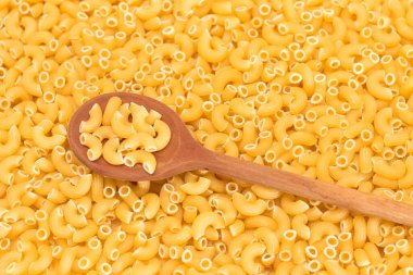 Tahta kaşıklı pişmemiş Chifferi Rigati Pasta Arkaplanı. Şişman ve Sağlıksız Yemek. Klasik Kuru Makarna. İtalyan Kültür ve Mutfağı. Çiğ Makarna