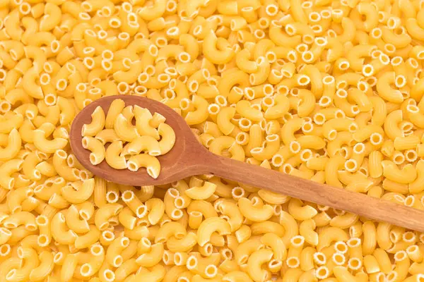 未烹调的Chifferi Rigati Pasta与Wooden Spoon的背景 脂肪和不健康的食物 经典的干通心粉 意大利文化与烹饪 Raw Pasta — 图库照片