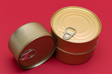 Kızıl Arkaplanda Boş Kenarlı İstiflenmiş Teneke Kutular. Konserve yiyecekler. Güvenli ve uzun vadeli yiyecek depolamak için farklı alüminyum kutular. Çelik Mühürlü Yiyecek Depolama Kutuları