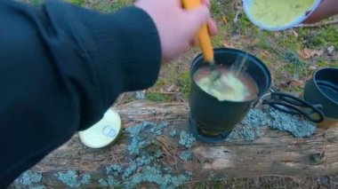 Camp Food. Cooking in a Hike Using a Small Cook Set - First Person View, Wide Angle. Food on the Trip. Traveler in a Spring Forest. Tourist in a Travel is Heating Food - POV Shot.