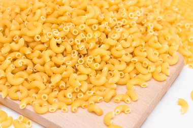 Tahta Mutfak Kurulu 'nda pişmemiş Chifferi Rigati Pasta yığını. Şişman ve Sağlıksız Yemek. Klasik Kuru Makarna. İtalyan Kültür ve Mutfağı. Çiğ Makarna