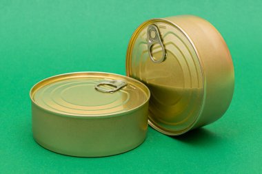 Yeşil Arkaplanda Boş Kenarlı İstiflenmiş Teneke Kutular Grubu. Konserve yiyecekler. Güvenli ve uzun vadeli yiyecek depolamak için farklı alüminyum kutular. Çelik Mühürlü Yiyecek Depolama Kutuları