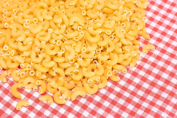 撒在红格子毛巾上的未煮熟的Chifferi Rigati Pasta 脂肪和不健康的食物 一大杯经典的干通心粉 意大利文化与烹饪 Raw Pasta — 图库照片