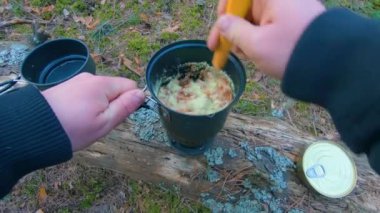 Camp Food. Cooking in a Hike Using a Small Cook Set - First Person View, Wide Angle. Food on the Trip. Traveler in a Spring Forest. Tourist in a Travel is Heating Food - POV Shot.