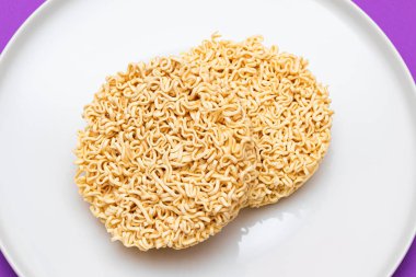 Beyaz Tabakta Pişmemiş Anında Erişte. Çiğ makarna. Kuru Asya Fast Food. Hızlı Öğle Yemeği