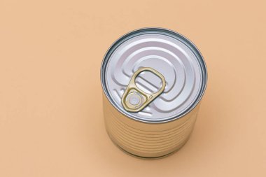 Unopened Tin Can with Blank Edge on Beige Background. Canned Food. Aluminum Can for Safe and Long Term Storage of Food. Steel Sealed Food Storage Container