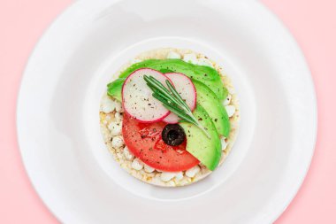 Avokado, domates, süzme peynir, zeytin ve turplu pirinç keki sandviçi. Kolay Kahvaltı 'da. Diyet yemek. Hızlı ve sağlıklı sandviçler. Lezzetli dolgulu kızarmış ekmek. Sağlıklı Beslenme Atıştırması