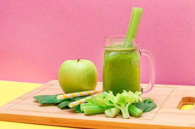 Taze Elma Smoothie, Kereviz ve Cam Smoothie Kavanozunda Ispanak ve Tahta Kesme Tahtasında Sarı Kokteyl Pipeti. Vejetaryen detoks içeceği. Vejetaryen Kültürü. Sağlıklı Yeme ve Meyve Diyet
