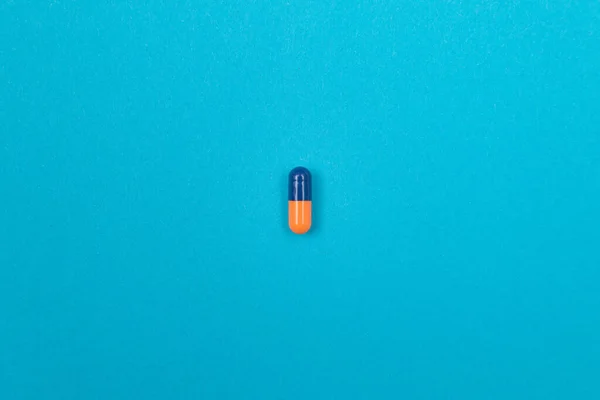 世界の医薬品産業と医薬品 青色の背景に散在するカラーピルまたはカプセル — ストック写真
