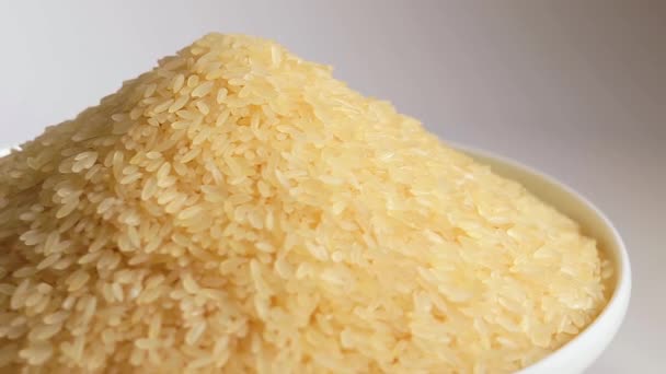 Dry Uncooked Parboiled Rice Heap Drehen Vor Weißem Hintergrund Ein — Stockvideo