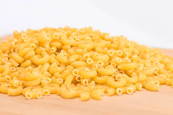 伍登厨房董事会的一堆堆未煮熟的Chifferi Rigati Pasta 脂肪和不健康的食物 经典的干通心粉 意大利文化与烹饪 Raw Pasta — 图库照片
