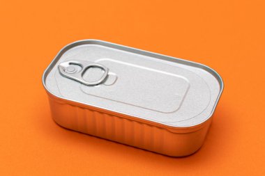 Turuncu Arkaplan 'da Boş Kenarlı Teneke Kutu. Konserve yiyecekler. Güvenli ve uzun vadeli yiyecek depolama için alüminyum kutu. Çelik Mühürlü Yiyecek Depolama Kutusu