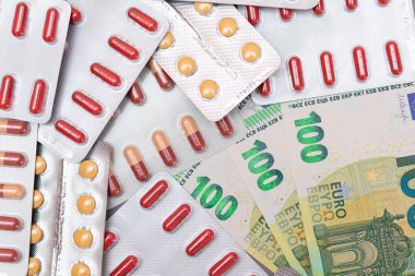 Pahalı İlaç ve Enflasyon Konsepti: Euro Banknotları üzerinde haplar ve kapsüller. Global İlaç Endüstrisi ve Büyük İlaç. Euro Para Faturaları
