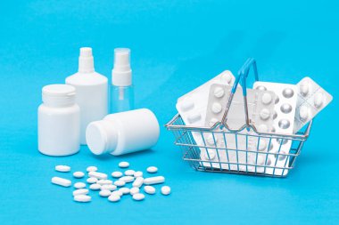 İlaç almak için. Pahalı İlaç ve Enflasyon Konsepti: Mavi Arkaplanda Alışveriş Sepeti 'nde haplar ve kapsüller. Global İlaç Endüstrisi ve Büyük İlaç. İlaç Ürünleri Siparişi