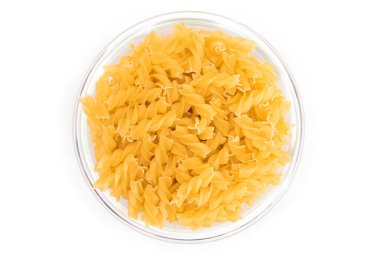 Cam kavanozdaki pişmemiş Fusilli Makarna Beyaz Arkaplanda izole edildi. Şişman ve Sağlıksız Yemek. Klasik kuru sarmal makarna. İtalyan Kültür ve Mutfağı. Çiğ Makarna