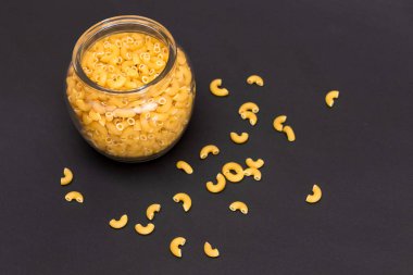Cam Kavanoz 'da pişmemiş Chifferi Rigati Makarnası. Şişman ve Sağlıksız Yemek. Dağıtılmış klasik kuru makarna. İtalyan Kültür ve Mutfağı. Çiğ Makarna