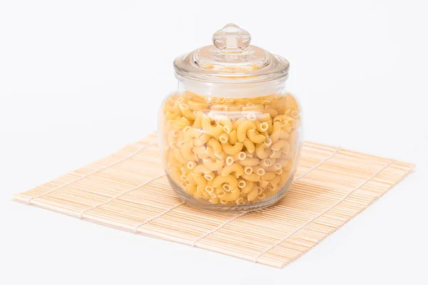 Uncooked Chifferi Rigati Pasta Glass Jar Bamboo Mat Isolated White — Stock Photo, Image