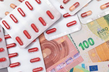 Pahalı İlaç ve Enflasyon Konsepti: Euro Banknotları üzerinde haplar ve kapsüller. Global İlaç Endüstrisi ve Büyük İlaç. Euro Para Faturaları