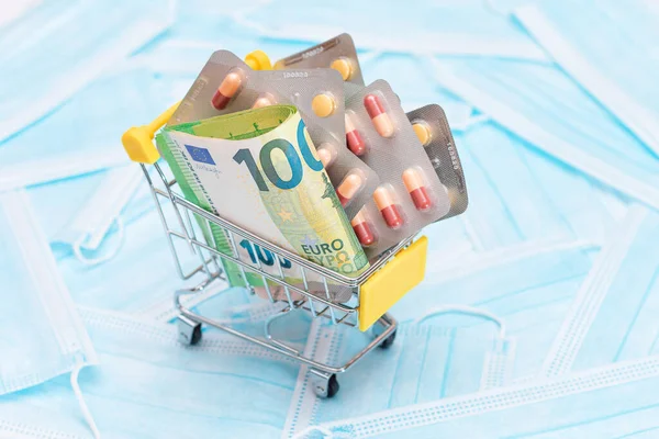 Buying Medicines. Expensive Medicine and Inflation Concept: Pills and Capsules in Shopping Cart on the Surgical Masks. Global Pharmaceutical Industry and Big Pharma. Ordering Pharmaceutical Products