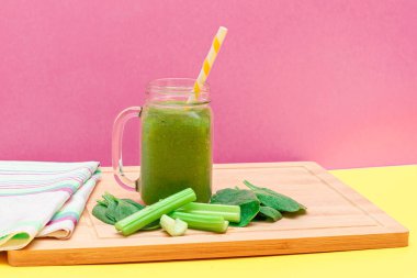 Taze Elma Smoothie, Kereviz ve Cam Smoothie Kavanozunda Ispanak ve Tahta Kesme Tahtasında Sarı Kokteyl Pipeti. Vejetaryen detoks içeceği. Vejetaryen Kültürü. Sağlıklı Yeme ve Meyve Diyet