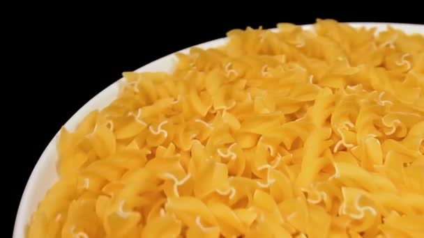 Ongebakken Fusilli Pasta Witte Plaat Die Tegen Zwarte Achtergrond Draait — Stockvideo