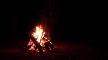 Karanlık Orman 'da Kara Arkaplan' da Gece Ateşi Yanıyor. Gece vakti Alevli Kamp Ateşi. Şenlik Ateşi için yer. Ateş Çukuru, Ateş Altında Orman, Uçan Kıvılcımlar ve Duman - Statik Atış