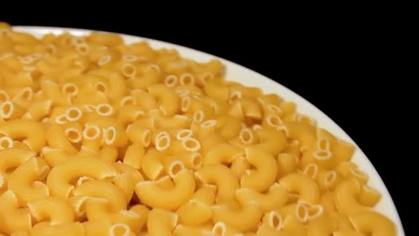 Ongekookte Chifferi Rigati Pasta Witte Plaat Roterend Tegen Zwarte Achtergrond — Stockvideo