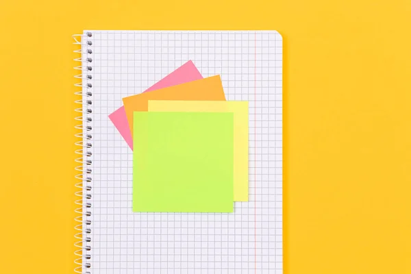 A Notepad with Sticky Notes Lying on Yellow Table - Blank Template. Top View, Flat Lay
