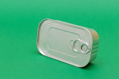 Yeşil Arkaplanda Boşluk Kenarı olan Kutulanmamış Teneke Kutu. Konserve yiyecekler. Güvenli ve uzun vadeli yiyecek depolama için alüminyum kutu. Çelik Mühürlü Yiyecek Depolama Kutusu