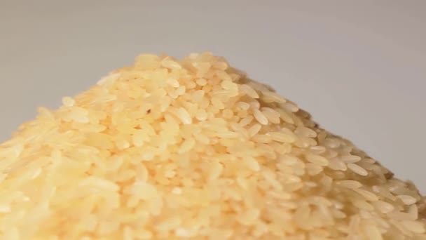 Droge Ongekookte Gekookte Rijst Heap Roterend Tegen Witte Achtergrond Een — Stockvideo