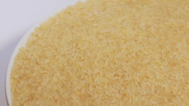 Ξηρό Άψητο Βραστό Ρύζι Λευκό Πιάτο Περιστρεφόμενο Λευκό Φόντο Σκορπισμένο — Αρχείο Βίντεο