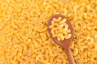 Tahta kaşıklı pişmemiş Chifferi Rigati Pasta Arkaplanı. Şişman ve Sağlıksız Yemek. Klasik Kuru Makarna. İtalyan Kültür ve Mutfağı. Çiğ Makarna