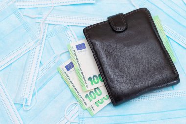 Black Mens Cüzdanı. Mavi Tek Kullanılabilir Tıbbi Yüz Maskeleri 'nin içinde Euro Para var. Tıbbi maske ticareti. Salgın ya da Salgın sırasında İş