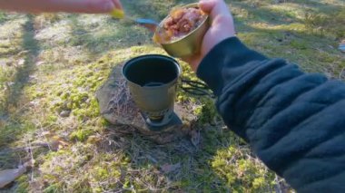 Camp Food. Cooking in a Hike Using a Small Cook Set - First Person View, Wide Angle. Food on the Trip. Traveler in a Spring Forest. Tourist in a Travel is Heating Food - POV Shot.