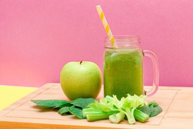 Taze Elma Smoothie, Kereviz ve Cam Smoothie Kavanozunda Ispanak ve Tahta Kesme Tahtasında Sarı Kokteyl Pipeti. Vejetaryen detoks içeceği. Vejetaryen Kültürü. Sağlıklı Yeme ve Meyve Diyet