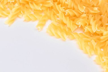 Beyaz Arkaplanda Kopya Alanı olan pişmemiş Fusilli Makarna. Çiğ ve kuru makarna. Şişman ve Sağlıksız Yiyecek - Düz Yat