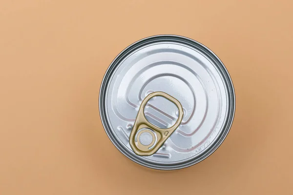 Unopened Tin Can with Blank Edge on Beige Background. Canned Food. Aluminum Can for Safe and Long Term Storage of Food. Steel Sealed Food Storage Container