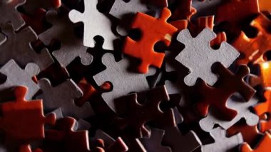 Saat Yönünün Tersine Yavaşça Dönen Renkli Bulmaca Parçalarının Arkaplanı - Üst Görünüm, Yakın Çekim. Tamamlanmamış Kırmızı ve Gri Yapbozun Yapbozu Düşük Anahtar Işıklı - Sol Döndürme