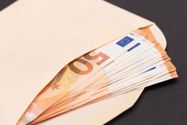 İçinde 50 Euro 'luk banknotlar olan bir Turuncu Kağıt Zarf. Nakit olarak maaş. Vergisiz sistem. Avrupa para birimi. Vergisiz ödemeler. Turuncu Kağıt Para. Bir sürü 50 Euro Fatura.